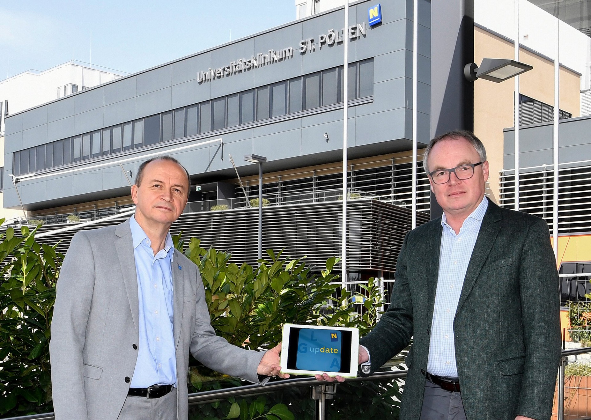 Präsentation der Mitarbeiter-App „LGA update“ auf einem Tablet vor dem Universitätsklinikum St. Pölten (Foto: NLK Reinberger)